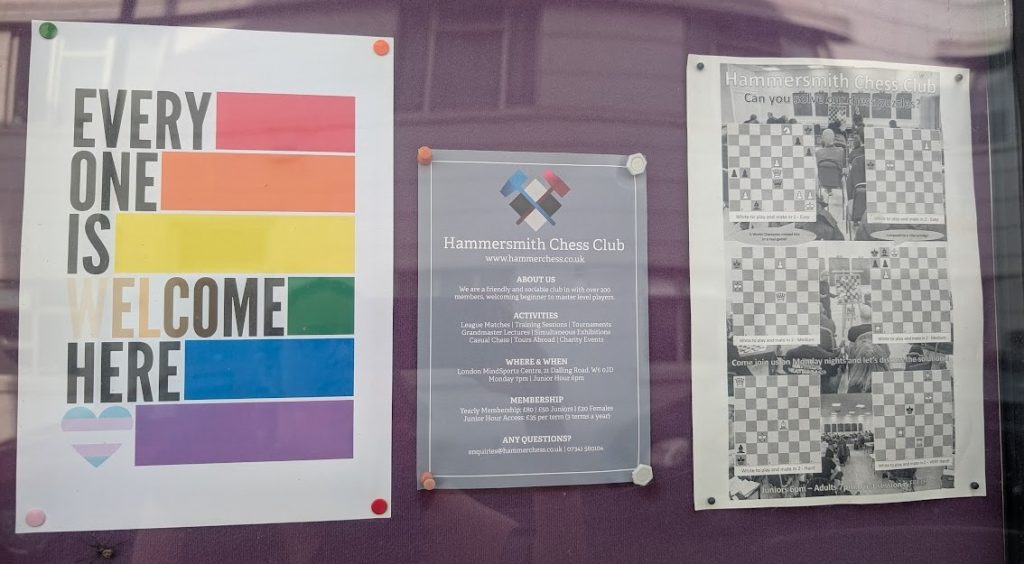 A poster up on the Hammersmith Chess Club noticeboard at then London Mindsports Centre. It has the colours of the rainbow flag plus a heart in the colours of the trans flag, and the text "everyone is welcome here".